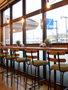 a row of bar stools in a restaurant with windows at Hotel St Palace Kurayoshi in Kurayoshi