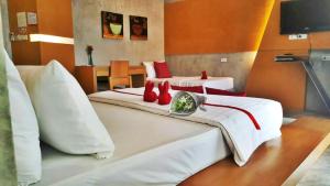 Habitación de hotel con 2 camas con almohadas rojas en The Now Hotel - SHA Extra Plus, en Jomtien Beach
