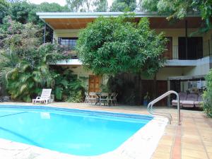 a swimming pool in front of a house at Managua Hills in Managua