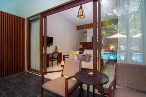 a living room with a table and a room with a pool at Apsara Residence Hotel in Siem Reap