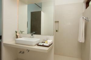 a white bathroom with a sink and a mirror at Apsara Residence Hotel in Siem Reap