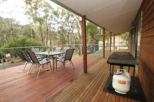 a patio with a table and chairs on a deck at Serene Vista Halls Gap in Halls Gap