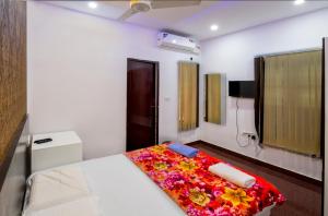 Rams Guest House Near Sree Chithra and RCC في تريفاندروم: غرفة نوم مع سرير مع بطانية ملونة عليه