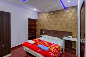 a bedroom with a large bed with a red blanket at Rams Guest House Near Sree Chithra and RCC in Trivandrum