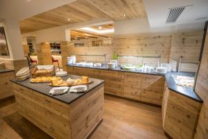 a large kitchen with wooden walls and wooden floors at Hotel Flachauerhof in Flachau