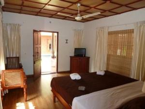 a bedroom with a bed and a television in it at Rajadhani 5th Season in Varkala