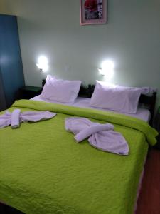 a bedroom with two beds with green sheets and white pillows at Smaragdi in Chania
