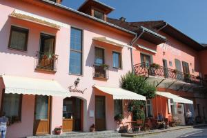 un edificio rosa con sombrillas blancas en una calle en Pension Ferdinand Panzio, en Sfântu-Gheorghe