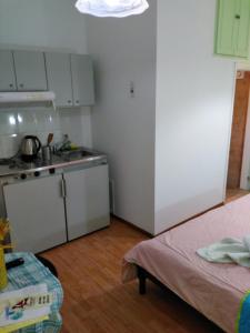 una pequeña cocina con fregadero y una cama en una habitación en Smaragdi, en La Canea