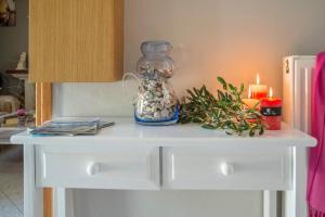 a white table with a vase and candles on it at Loggos Seaview Cottage with Pool by Konnect in Longós