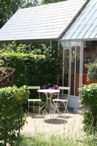 un patio con tavolo e sedie in giardino di B&B La Chambre d'à Côté ad Aische-en-Refail