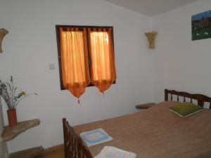 サン・ポール・ド・ヴァンスにあるMaisonette La Pinedeのベッドルーム1室(テーブル付)、窓(オレンジ色のカーテン付)
