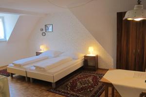 ein Schlafzimmer mit einem Bett, zwei Tischen und zwei Lampen in der Unterkunft Bed & Breakfast Sonne in Bregenz