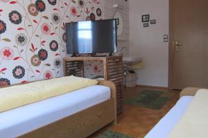 a room with two beds and a flat screen tv at Bed & Breakfast Sonne in Bregenz