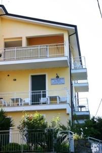 un edificio amarillo con balcones en un lateral en B&B La Baia Di Fiascherino citr01101sei-BEB-0011, en Tellaro
