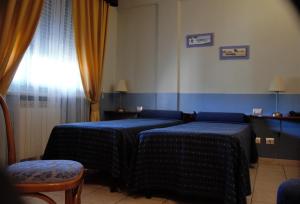 a hotel room with two beds and a television at Hotel Morgana in Marina di Carrara