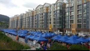 a large building with blue umbrellas in front of it at Golden Hill 1 Room Apt at Night Market in Cameron Highlands
