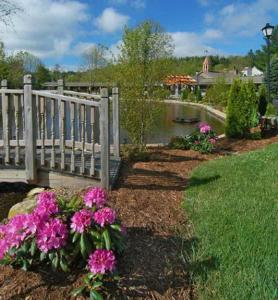einen Garten mit rosa Blumen neben einem Zaun in der Unterkunft Village Inn - Blowing Rock in Blowing Rock