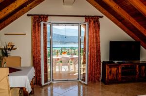 salon z przesuwnymi szklanymi drzwiami prowadzącymi na patio w obiekcie Simona's Loft w mieście Argostoli