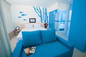 a blue couch in a room with a bed at R-Con Blue Ocean in Pattaya +19 photos