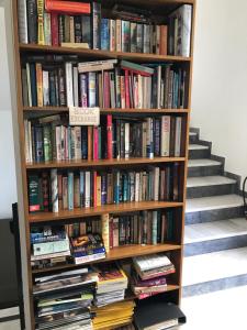 a book shelf full of books next to a staircase at Hotel Pelops in Olympia