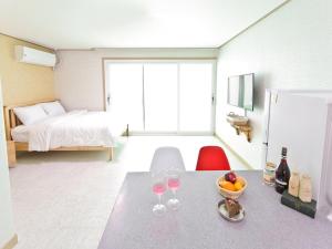 a room with a table with wine glasses and a bed at Sky Vivaldi Pension in Hongcheon