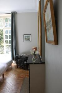 una habitación con una mesa con un jarrón de flores en un mostrador en Chambres d'Hôtes Château de Martragny, en Martragny