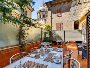a patio with tables and chairs and a building at Lh Royal Suites Terrace in Rome