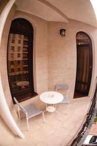 a table and two chairs and a table and two windows at Guest House BoNaMi in Anapa