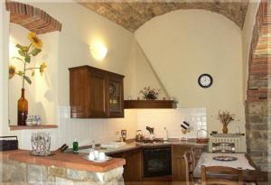 een keuken met een tafel en een klok aan de muur bij Casa Vacanze Vertine in Gaiole in Chianti