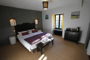 a bedroom with a large bed and a dresser at La Haute Flourie - bed and breakfast -chambres d'hôtes in Saint Malo