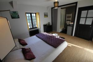 a bedroom with a large bed with pillows on it at La Haute Flourie - bed and breakfast -chambres d'hôtes in Saint Malo