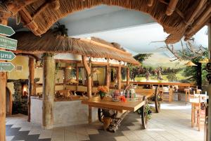 ein Restaurant mit Tisch und Stühlen und einem großen Sonnenschirm in der Unterkunft Kelten-Hotel in Sünna