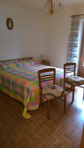 サッパーダにあるLanner Appartamenti Silvanoのベッドルーム1室(ベッド1台、椅子2脚付)