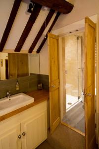 uma casa de banho com um lavatório e um chuveiro em Eight Bells Inn em Chipping Campden