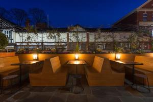 een patio met 2 tafels, stoelen en verlichting bij The Bull & Stirrup Hotel Wetherspoon in Chester