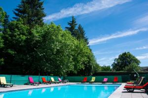 a row of colorful chairs next to a swimming pool at Logis Le Ceans in Orpierre