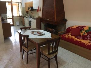 uma cozinha e sala de jantar com mesa e cadeiras em Anna Apartment em Villaputzu