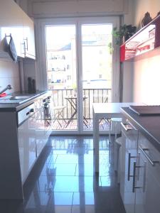 uma cozinha com uma mesa e vista para uma varanda em Cozy Apartment Ulmenstrasse em Lucerna