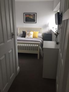 a bedroom with a bed with a pillow on it at Copper's Cottage in Sheringham