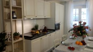 a kitchen with white cabinets and a table with fruits at Luxury apartment Suite La Fontana in Lucca