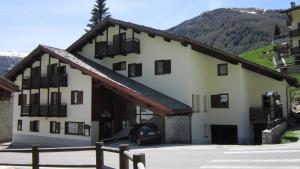 a building with a car parked in front of it at Hotel Bel Sit in Madesimo