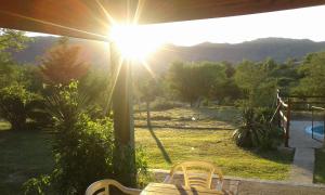 een uitzicht op een tuin met een bank en de zon bij Postal Serrana in Villa Parque Siquiman