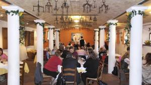 Agriturismo Corte dei Landi في Cadè: مجموعة من الناس يجلسون على الطاولات في القاعة