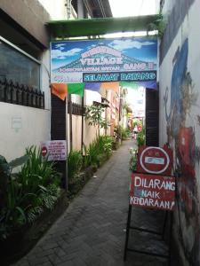 une rue avec des panneaux sur le côté d'un bâtiment dans l'établissement Losmen Fadel Malioboro Jogja, à Yogyakarta