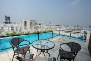a balcony with a table and chairs and a pool at Golden Tulip The Grandmark Dhaka in Dhaka