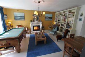 a living room with a pool table and a fireplace at La Haute Flourie - bed and breakfast -chambres d'hôtes in Saint Malo