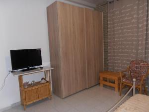 ein Wohnzimmer mit einem TV und einem Holzschrank in der Unterkunft B&B Colle Acquabella in Ortona
