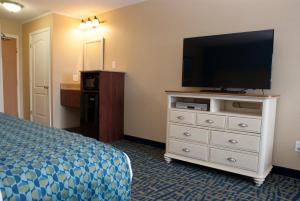 a hotel room with a bed and a flat screen tv at Grand Beach Resort Hotel in Traverse City