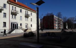 una luz de la calle frente a un edificio blanco en M. Mažvydo al. butas, en Klaipėda